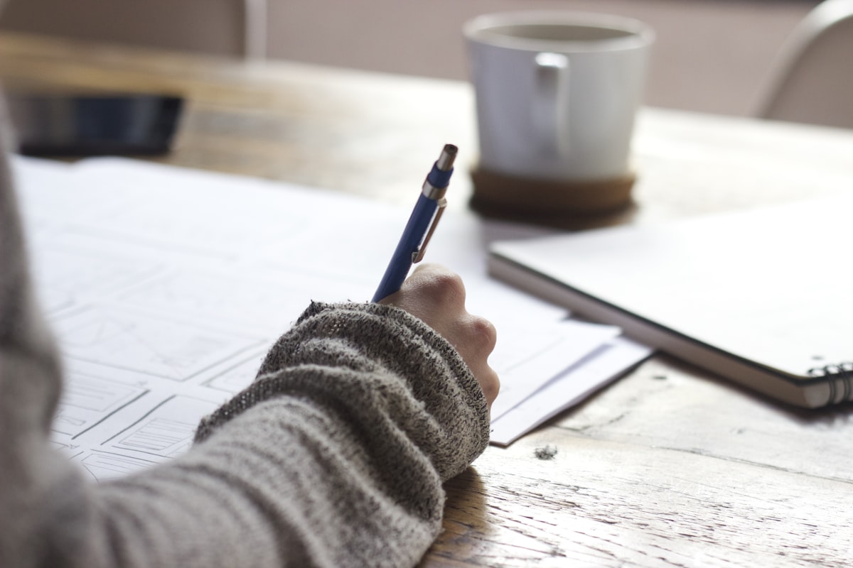 Person writing notes at a desk, organizing professional relationships